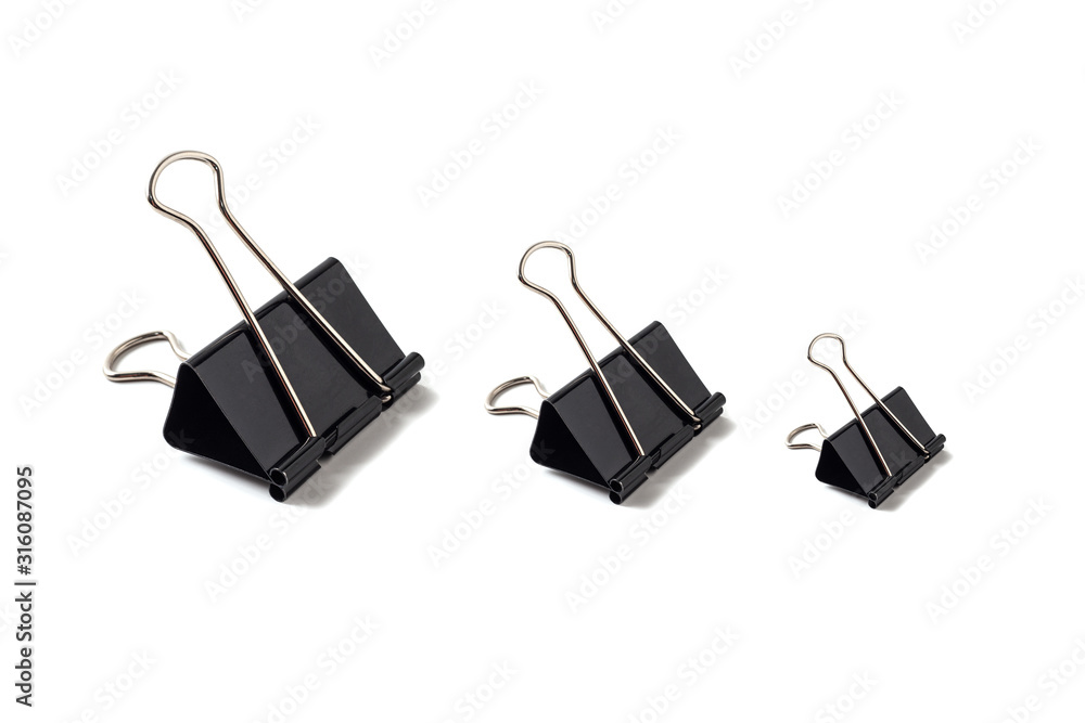 Black metal binder clips on white background isolated. Office paper clips tool for paper documents clamping. Stationery. Black metal binder clips on white background isolated. Office paper clips tool for paper documents clamping. Stationery.