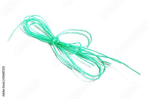 Green plastic rope skein to tie up on isolate white background. The remains of the old cord.