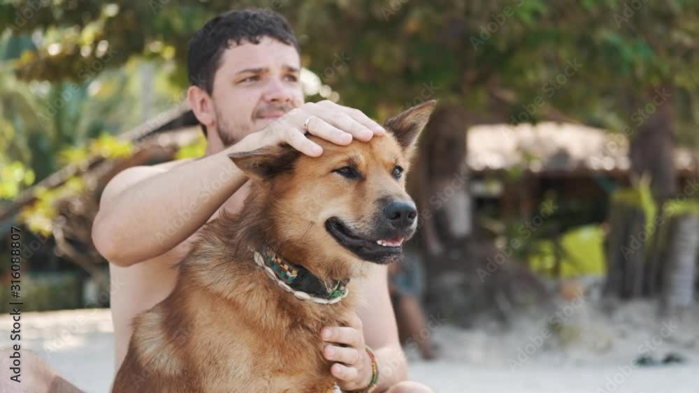 Young guy with his red dog friend at the beach Young guy with his red dog friend at the beach