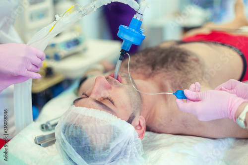 Anesthesiologist performing tracheal intubation in operation room. Preparation for surgery. Rhinoplasty