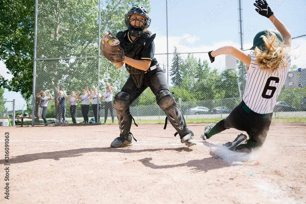 Fotka „Middle school girl softball player sliding into home base next ...