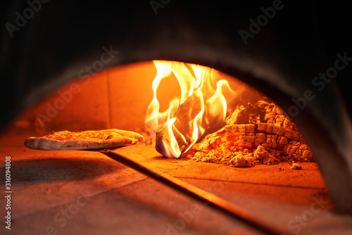 Baked tasty margherita pizza in Traditional wood oven in Naples restaurant, I...