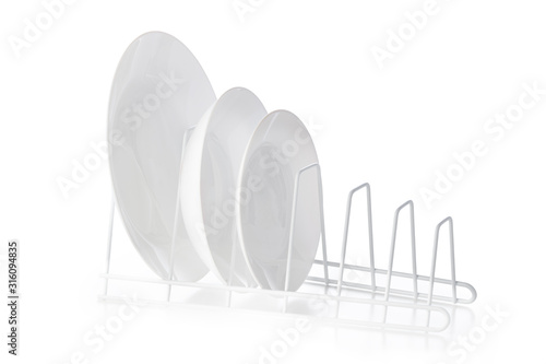 Set of white ceramic dishware on drainer
