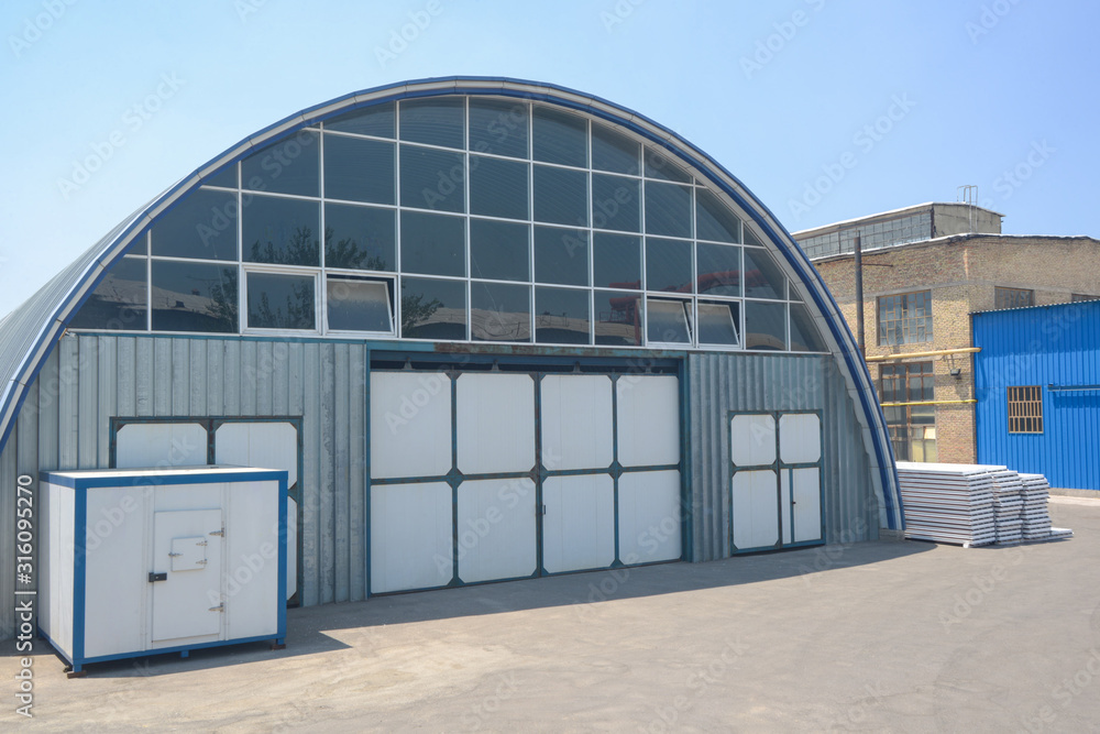 facade of an industrial warehouse with an oval roof facade of an industrial warehouse with an oval roof