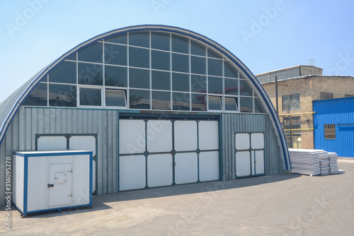 facade of an industrial warehouse with an oval roof