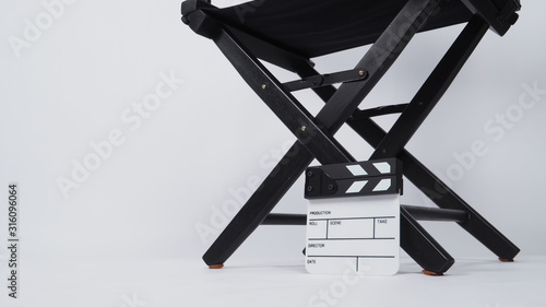 Small Clapper board or movie slate with black director chair use in video production or movie and cinema industry. It's put on white background.