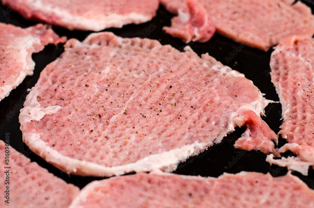 Cooking: chopped pork pieces sprinkled with ground pepper Cooking: chopped pork pieces sprinkled with ground pepper