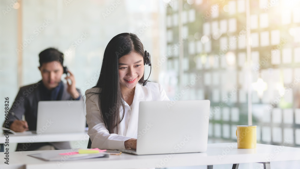 Close up view of customer service  talking on headset with smiling  in office room