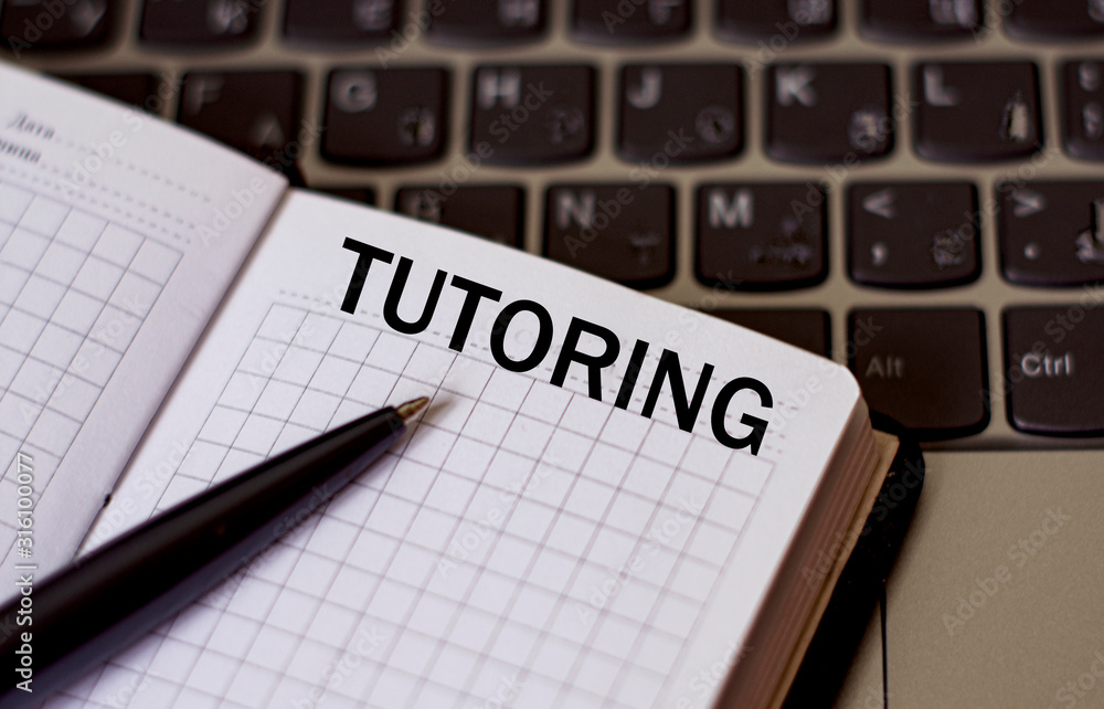 concept word tutoring on a sheet of notepad against the background of the keyboard concept word tutoring on a sheet of notepad against the background of the keyboard