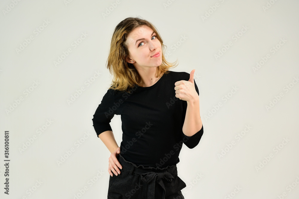 Studio portrait of a pretty blonde girl in a black T-shirt on a white background with bright emotions. A universal concept, the picture is suitable for any topic. Studio portrait of a pretty blonde girl in a black T-shirt on a white background with bright emotions. A universal concept, the picture is suitable for any topic.