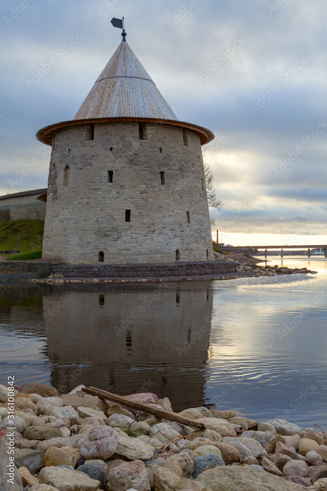 The watchtower of the Pskov Kremlin reflected on the water on the western border of Russia