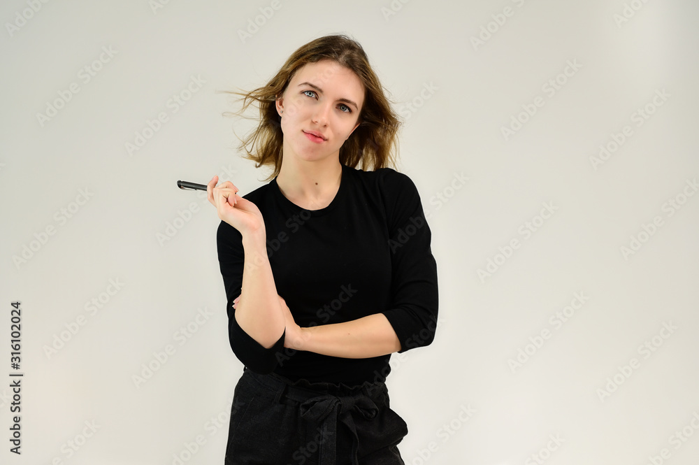 A universal concept, the picture is suitable for any topic. Studio portrait of a pretty blonde girl in a black T-shirt on a white background with bright emotions. A universal concept, the picture is suitable for any topic. Studio portrait of a pretty blonde girl in a black T-shirt on a white background with bright emotions.
