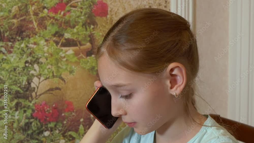 Portrait teenager girl talking by mobile phone in domestic interior. Face young girl calling smartphone in home room Portrait teenager girl talking by mobile phone in domestic interior. Face young girl calling smartphone in home room