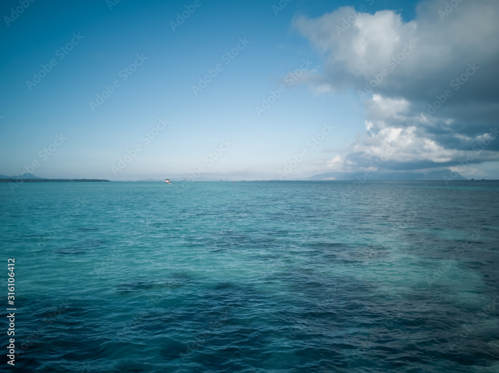 wide panorama of sea against sky at the tropical island in Semporna, Borneo Sabah, Malaysia.
