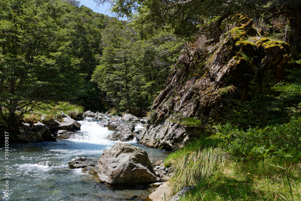 A river runs through boulders in a valley A river runs through boulders in a valley