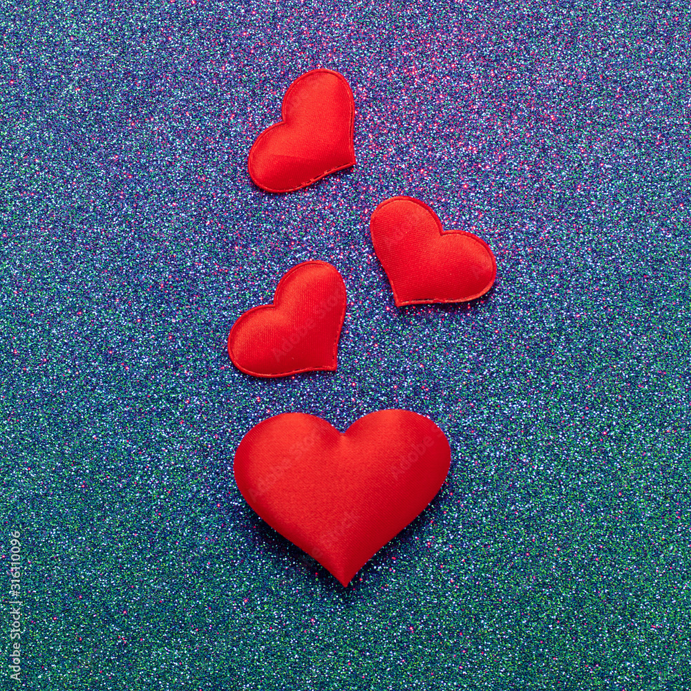 Obraz premium Red hearts symbol of love on a shiny blue background. Valentines day concept. Horizontal frame copy space.