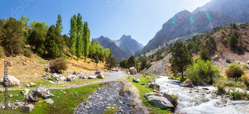 Fototapeta Naklejka Na Ścianę i Meble -  Scenery summer panorama of mountains, stormy mountain river and narrow  track. Forest is along stormy mountain river. Summer adventure