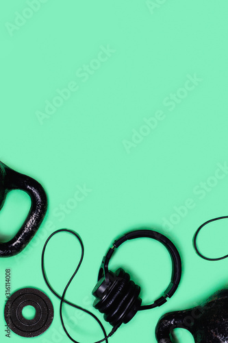 Sports picture. Kettlebells and dumbbells on mint green background. Flat lay, top view, copy space.