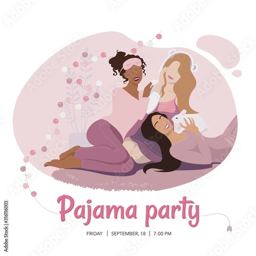 Three happy girls of diverse race in pink nightwear sitting on the carpet and playing with rabbit. Pajama party.
