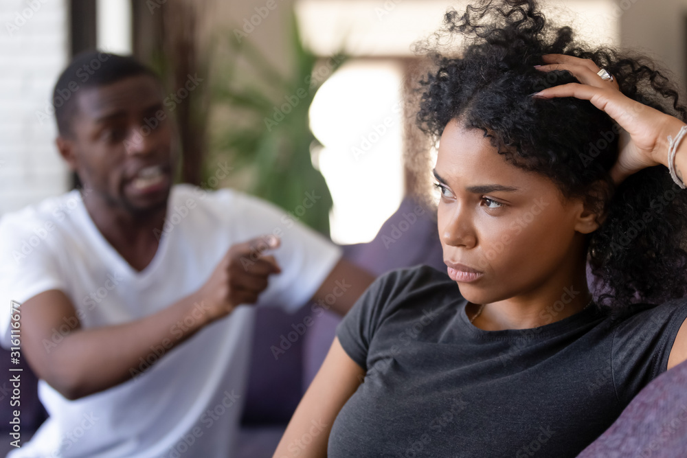 Obraz premium Emotional black husband blame indifferent wife in fight