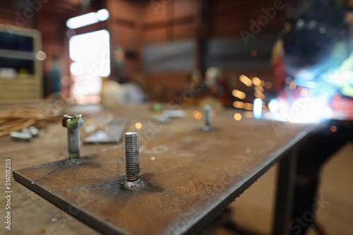 Картината върху платно Clear steel bolts welded into the metal plate at the construction fabrication ta