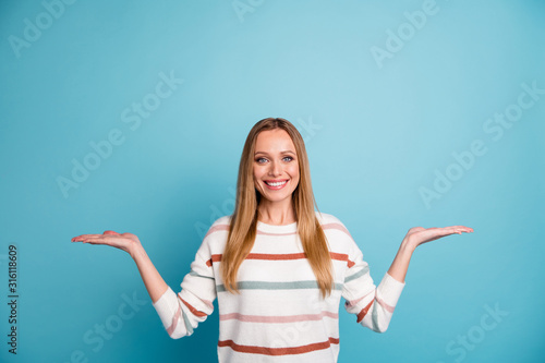 Photo of blonde haired cheerful toothy beaming woman holding two sides of one option for you to estimate isolated empty space pastel color background photo