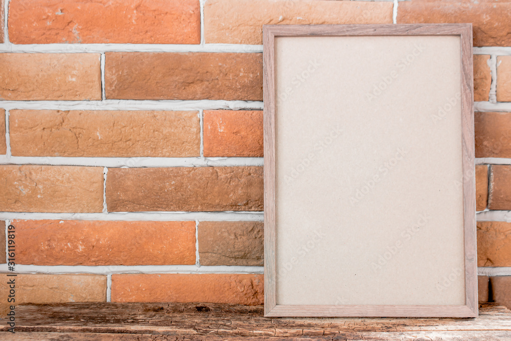 Fototapeta premium empty photo frame on brick background with place for text