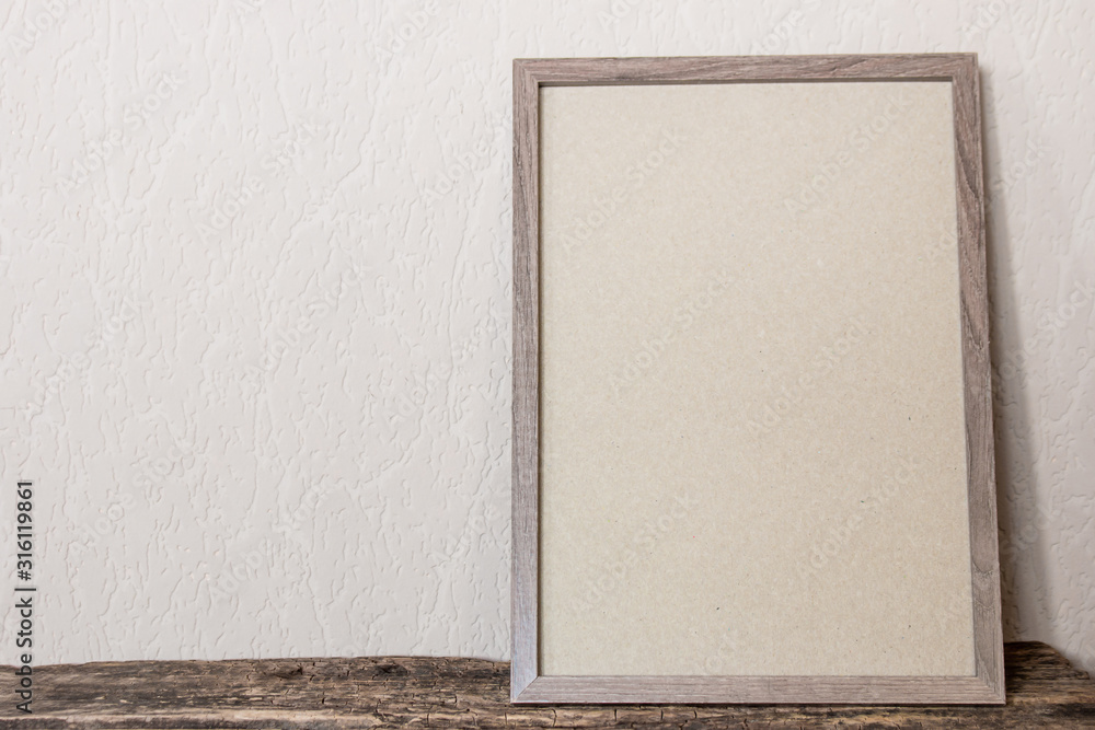 Fototapeta premium empty photo frame on wooden background with place for text