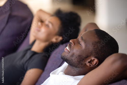 Close up of black couple relax on couch dreaming