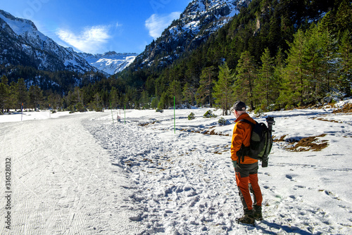 hiker man walking on snowy Pyrenees mountains, Cauterets photo