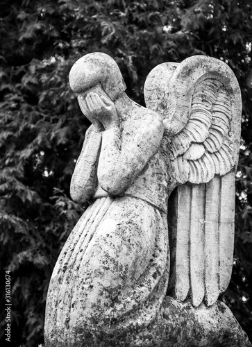 An abstract image of a sad angel who mourns the loss with his hands in his crying eyes.