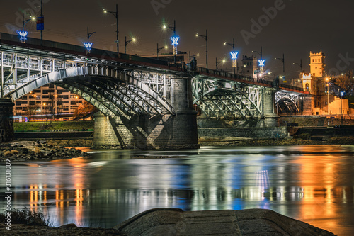 Nocne zdjęcie oświetlonego mostu Poniatowskiego w Warszawie