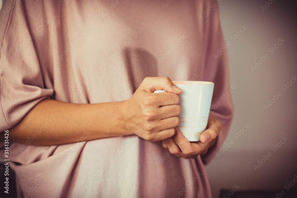 Unrecognizable woman holding white mug. Unrecognizable woman holding white mug.