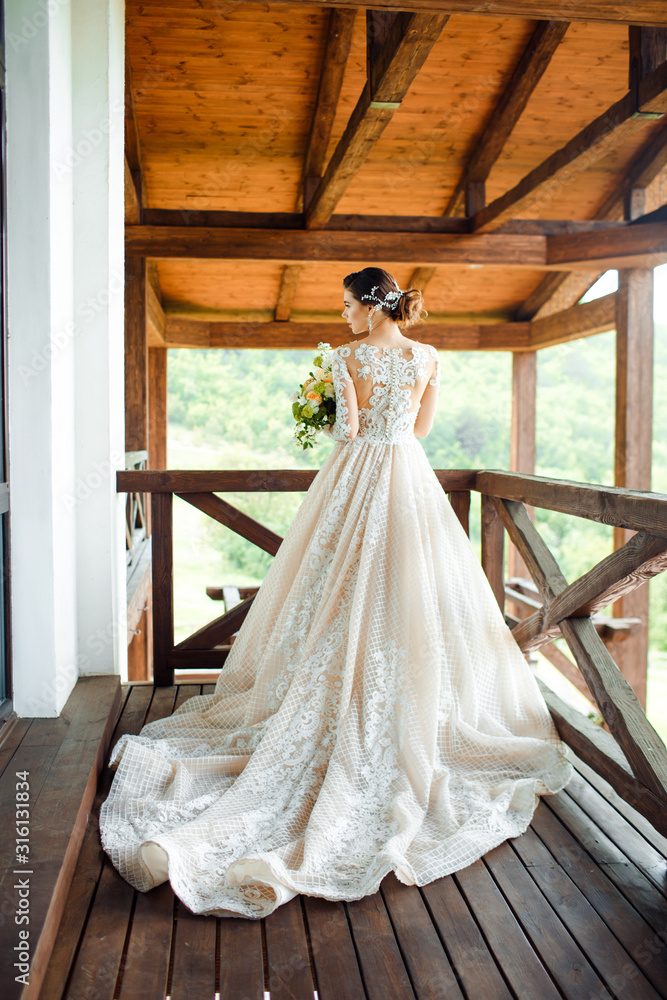 The bride in a magnificent, white, wedding dress with a long train.