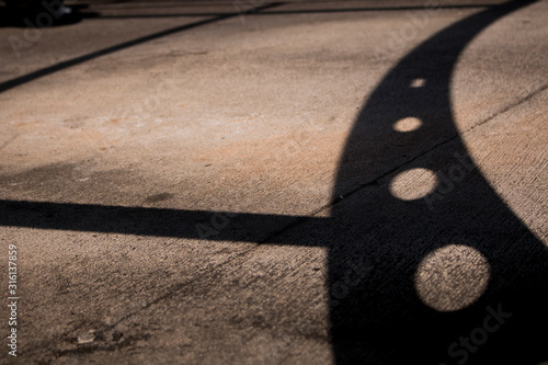 Ombra di una tettoia per le biciclette sul pavimento in cemento, giochi di ombre in città photo