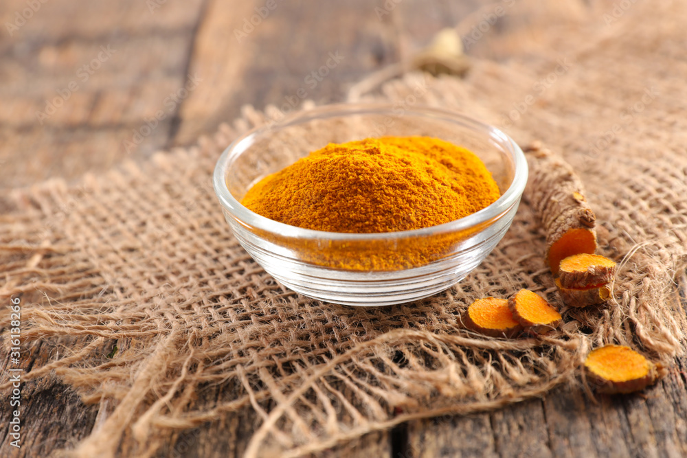 curcuma spice root on wood background curcuma spice root on wood background