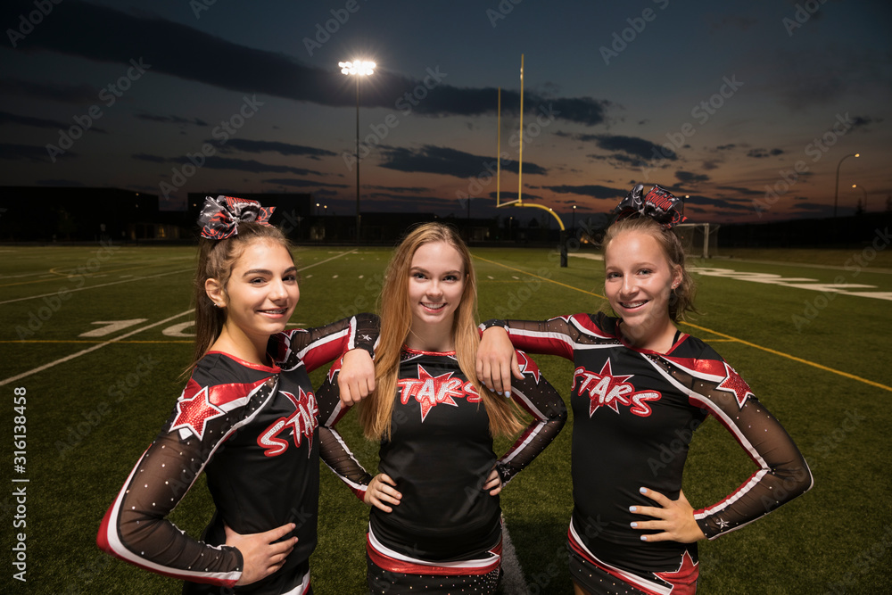 Portrait confident teenage girl high school cheerleaders on football ...