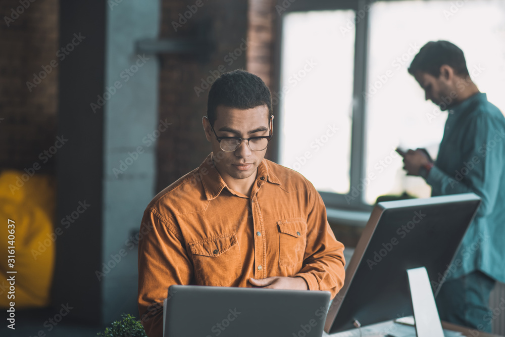 Smart diligent young man focusing on his work Smart diligent young man focusing on his work