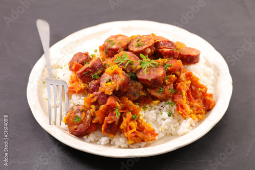 plate with rice and spicy sausage with tomato sauce