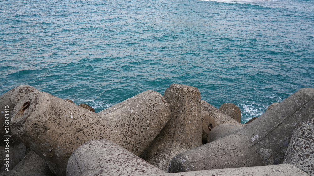 Unusual triangular breakwater in the blue stormy sea. tripods on the Pacific coast in Japan. sea ​​foam