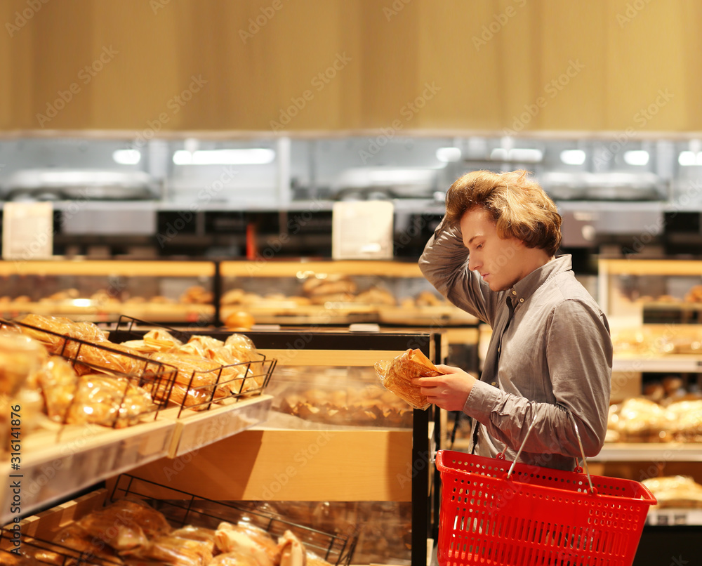 Teenager choosing bread from a supermarket	