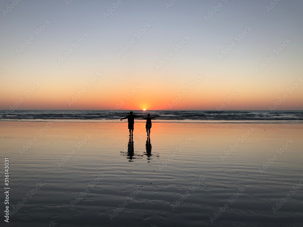 Fototapeta premium silhouette of woman on pier at sunset