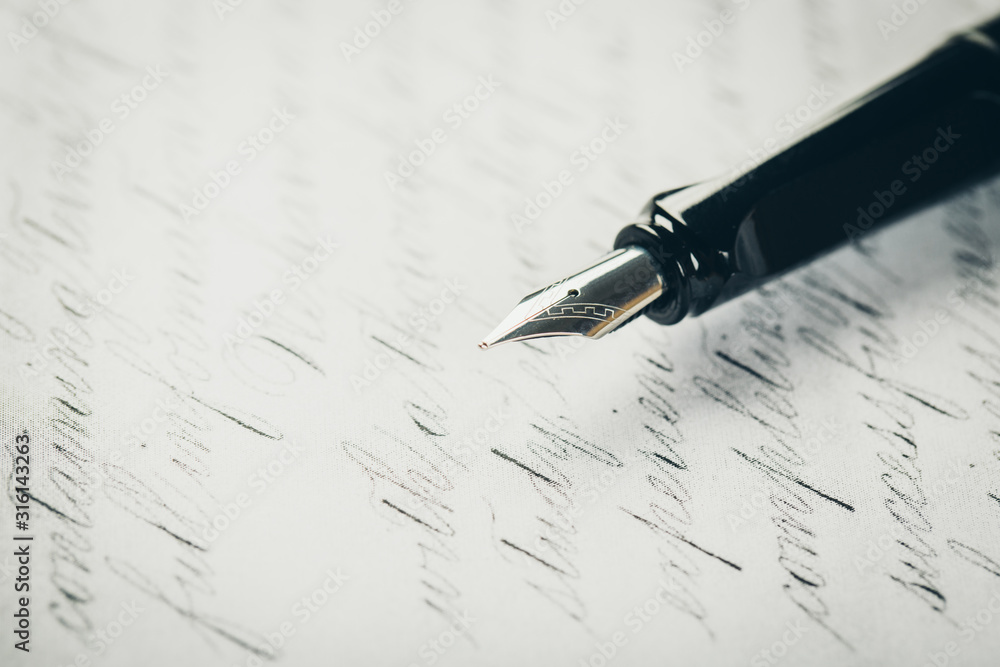 Fototapeta premium Fountain pen on an ancient handwritten letter. Old story. Retro style.