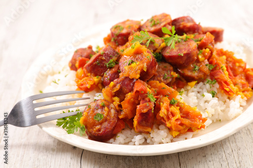 plate with rice and spicy sausage with tomato sauce
