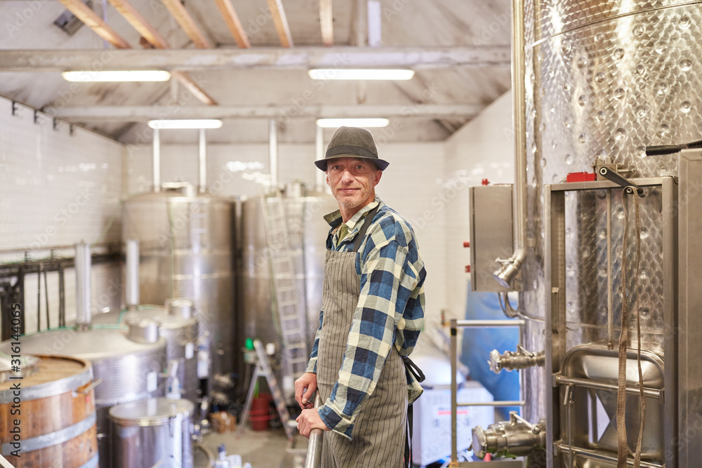 Mann als Winzermeister in der Weinkellerei