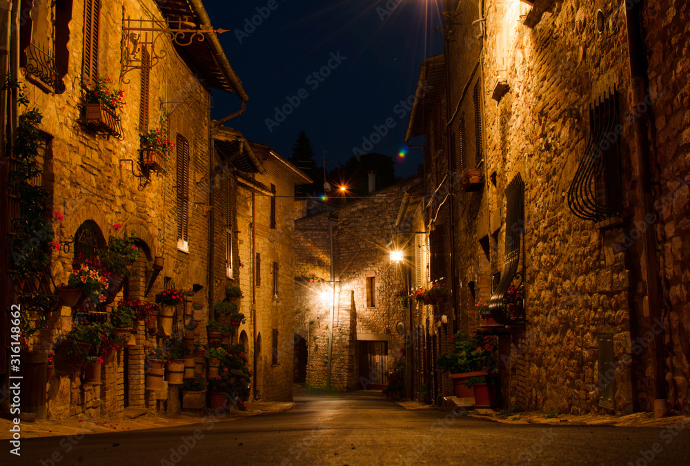 A medieval picturesque street in Assisi by night