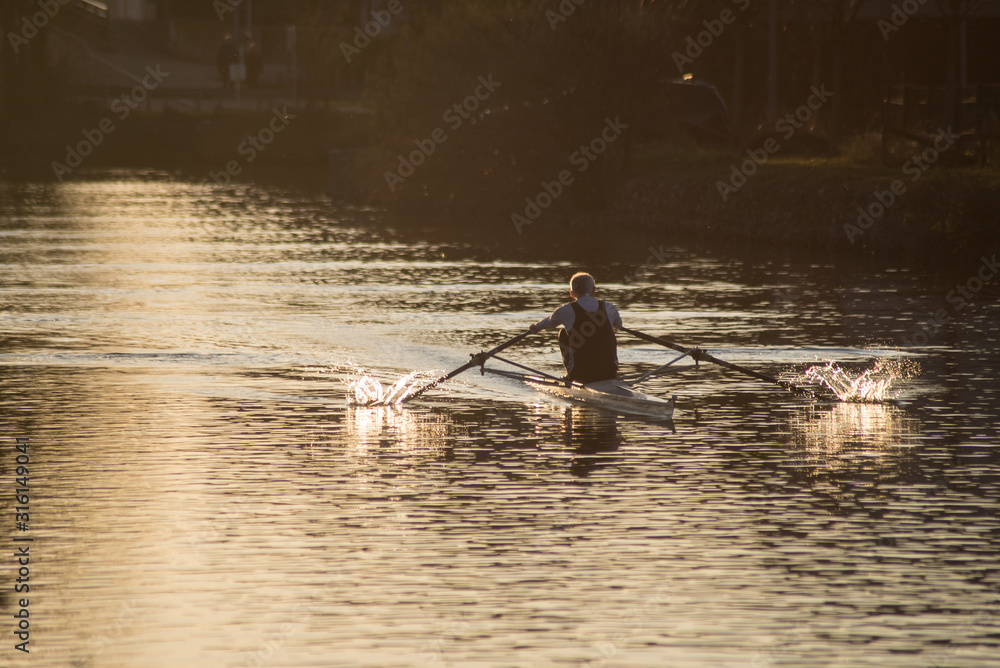 Naklejka premium portrait on back view of old man rowing on the river