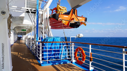 walk deck on a cruise ship. safety on the ship, lifeboat, liferafts, lifebuoys. liferaft station. blue ocean. white ship in the blue ocean. large cruise ship photo