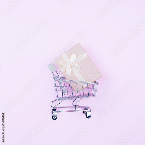 Shopping cart and gift box in it. The concept of online shopping