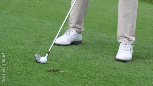 Professional golfer started a game golf. Golfer taking shot on the golf course.